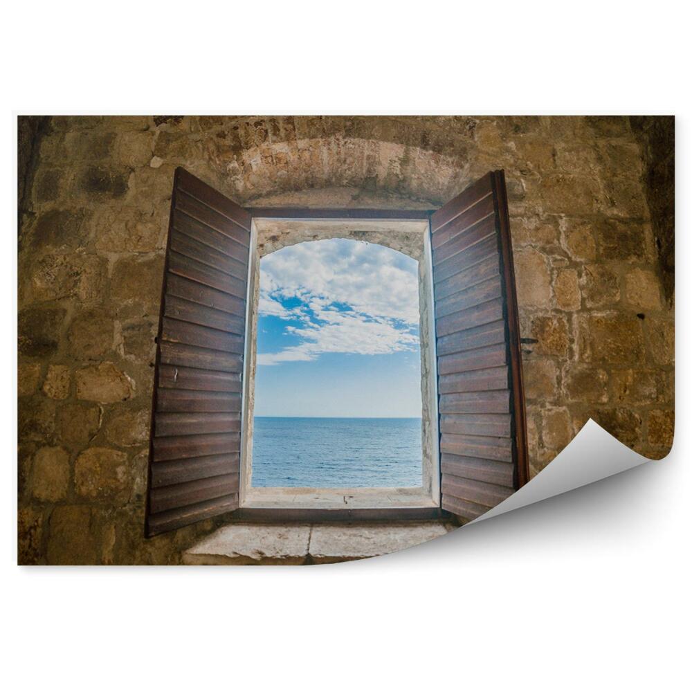 Papier peint Fenêtre dans le mur d'un vieux fort vue sur la mer
